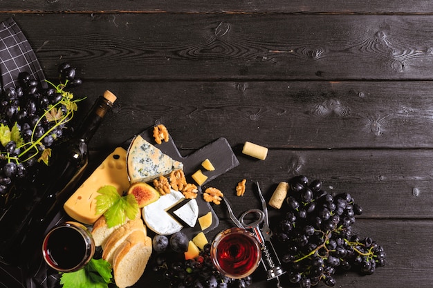 Vino con ramas de uvas blancas. Sobre una mesa de madera.