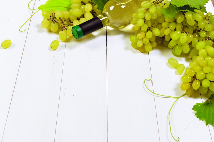 Foto vino con ramas de uvas blancas.