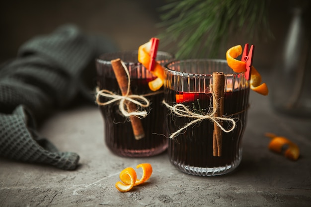 Vino tinto caliente de Navidad con especias aromáticas y frutas cítricas en caja de madera, primer plano. Bebida caliente tradicional en Navidad