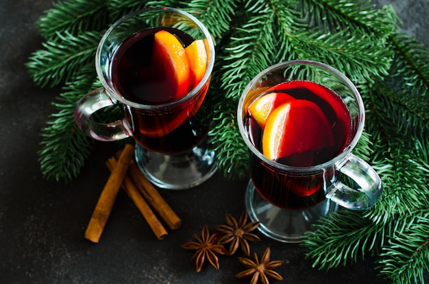 Vino tinto caliente de Navidad con especias en la oscuridad