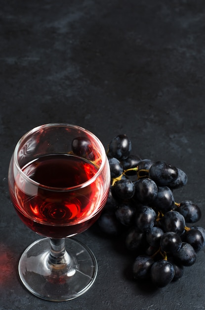 Vino tinto en copa, racimo de uvas