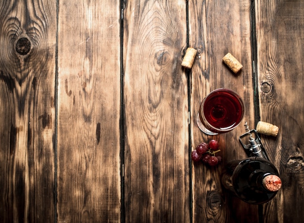 Vino tinto con corchos de mesa de madera.