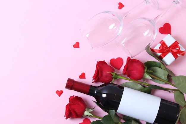 Vino tinto y rosas sobre la mesa de fondo del día de San Valentín