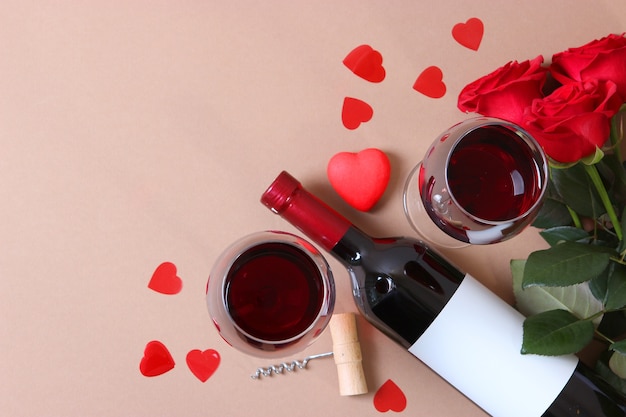 Vino tinto y rosas sobre la mesa de fondo del día de San Valentín