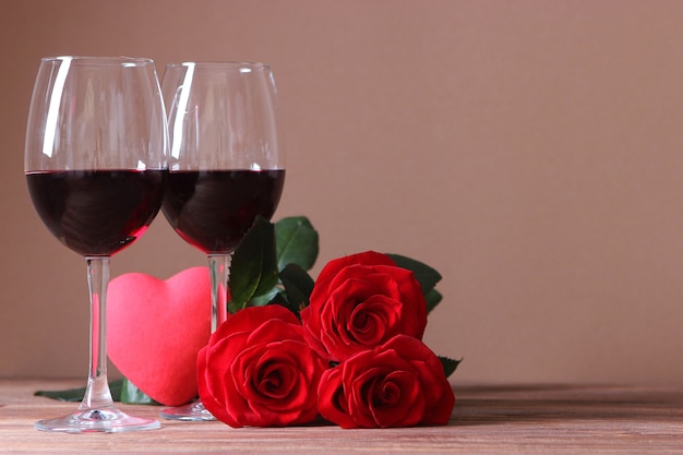 Vino tinto y rosas sobre la mesa de fondo del día de San Valentín