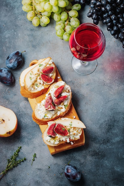 Vino tinto con snacks bruschetta con peras requesón higos tomillo nueces y miel queso camembert