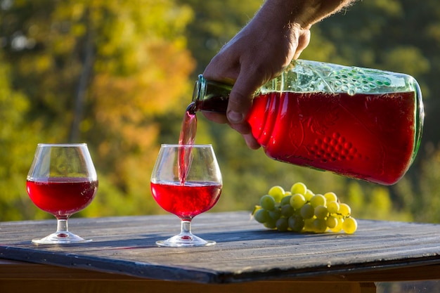 Vino tinto en un vaso y una botella de fondo borroso