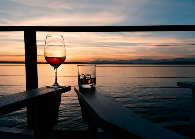 Vino y whisky en sillas de cubierta al atardecer sobre el paisaje marítimo