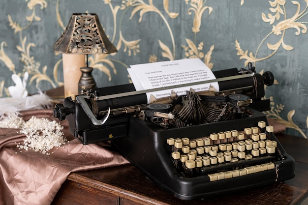 Vintage alte Schreibmaschine auf dem Retro-Tisch. Retro-Interieur mit den alten Möbeln und dem Vintege-Spiegel an der Wand.