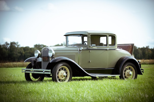 Vintage-Auto auf dem Feld gegen den Himmel