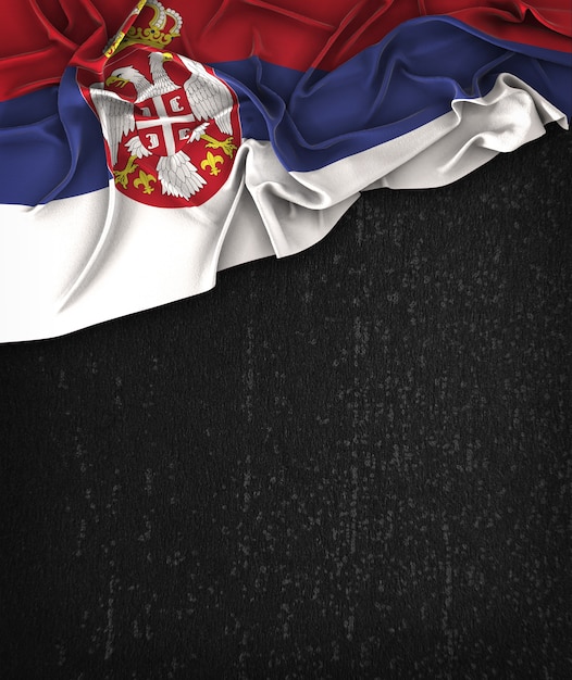 Foto vintage de la bandera de serbia en una pizarra negra del grunge con el espacio para el texto