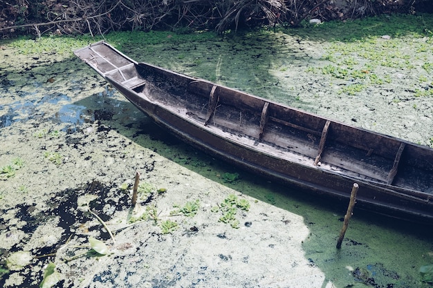 Vintage barco de madera en el río. Barco de madera de pie cerca de la orilla del río.