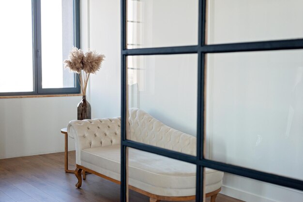 Vintage Beige Sofa in Velourspolsterung in einem modernen Interieur mit einer Vase mit getrockneten Blumen Innenarchitektur Weicher selektiver Fokus