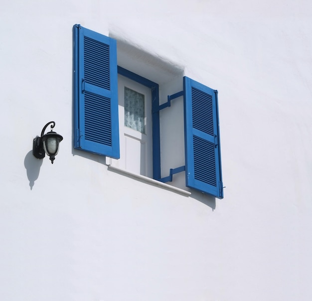 Vintage blaues Fenster an der weißen Wand