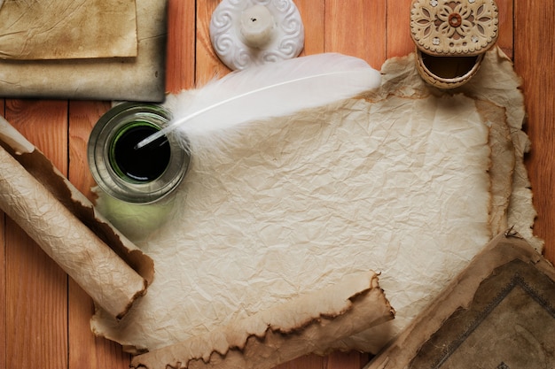 Vintage bodegón con pluma, papel viejo y vela encendida sobre fondo de lienzo