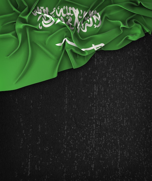 Vintage da bandeira de Arábia Saudita em um quadro preto do Grunge com espaço para o texto