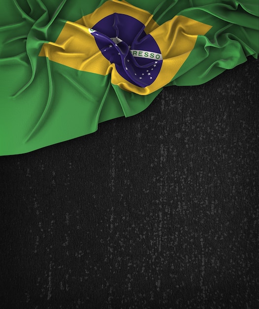 Vintage da bandeira de brasil em um quadro preto do grunge com espaço para o texto