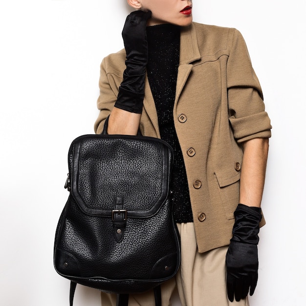 Vintage Fashion Studentin Beige klassisches Kostüm und stilvolle Accessoires. Roter Lippenstift, Handschuhe. Rucksack-Mix-Trends und Vintage-Outfit