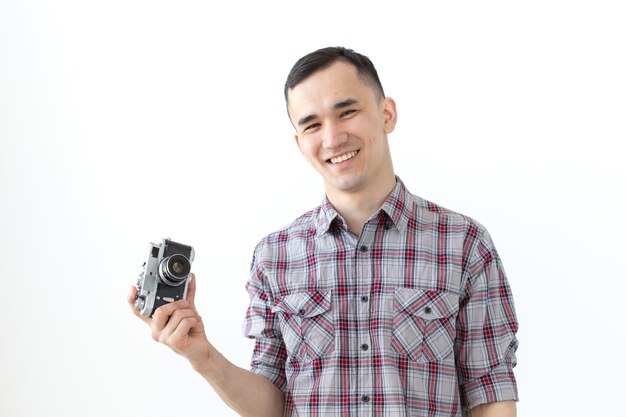 Vintage, Fotograf und People-Konzept - gut aussehender Mann mit Retro-Kamera auf weißem Hintergrund mit Kopienraum.