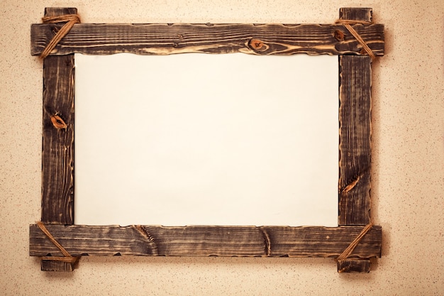 Foto vintage holzrahmen mit leinwand an der wand aufgehängt. kunsthintergrund