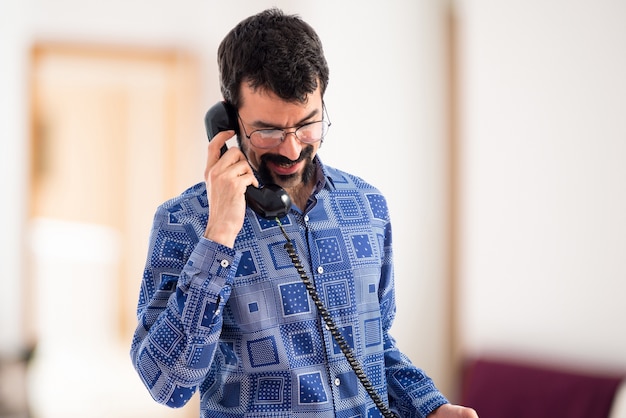 Vintage junge Mann im Gespräch mit Vintage Telefon auf unfocused Hintergrund