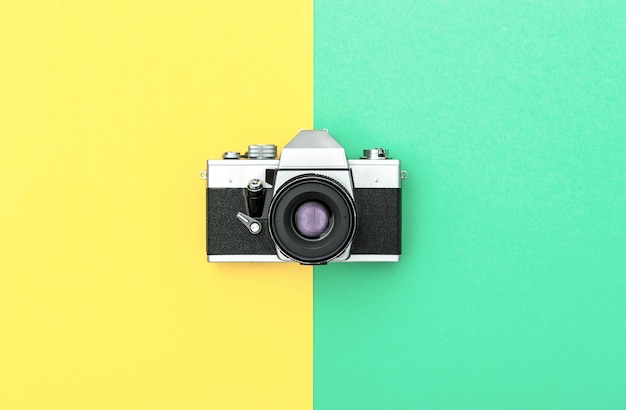 Vintage-Kamera auf farbigem Hintergrund. Getöntes Bild im Retro-Stil. Minimalistisches Konzept
