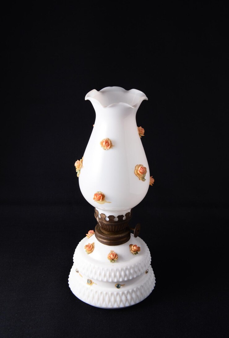 Una vintage lámparas de aceite de porcelana blanca con ornamento floral en fondo negro