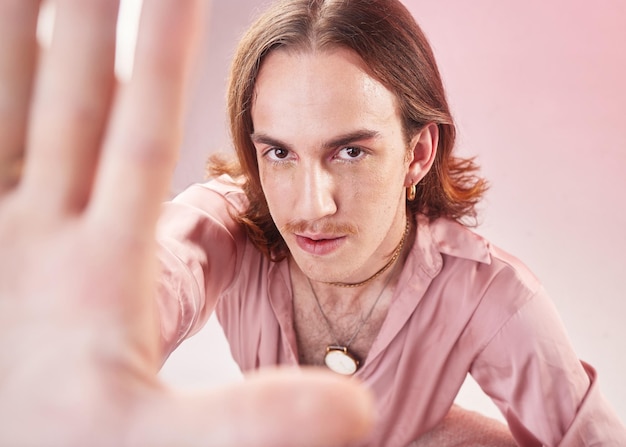 Foto vintage-mann-mode-selfie und studioporträt für 70er-hippie oder psychedelische ästhetik durch rosa hintergrund gen z-model retro-kleidung oder profilbild in der app für soziale netzwerke für kreative influencer