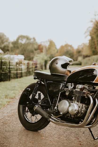 Vintage moto y casco estacionado en campo