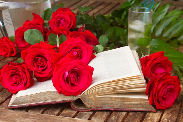 Vintage offenes Buch auf Tisch mit roten Rosen