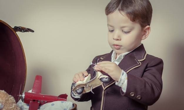 Vintage retrato de niño jugando con juguetes de hojalata