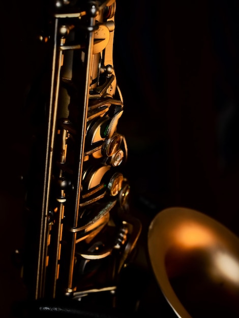 Foto vintage saxophon alto sax jazz musikinstrument nahaufnahme mit selektivem fokus auf schwarzem hintergrund