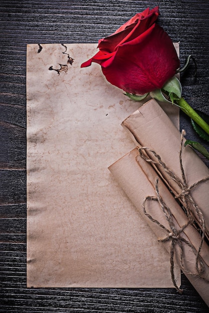 Vintage schnurgebundene Papierrollen rot blühte Rose auf Holzbrett