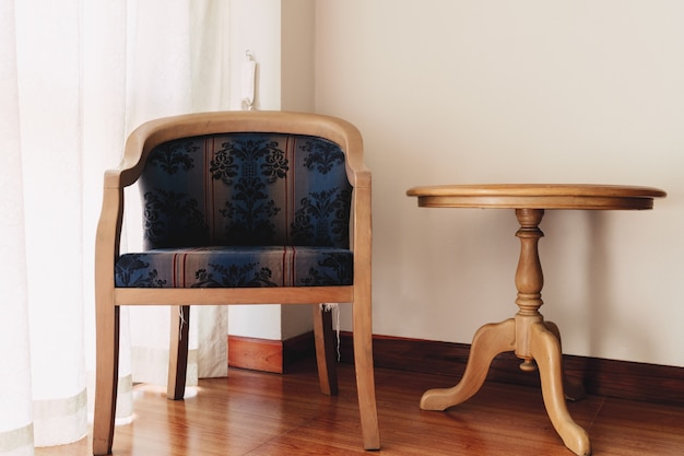 Vintage silla y mesa en la ventana en la habitación.