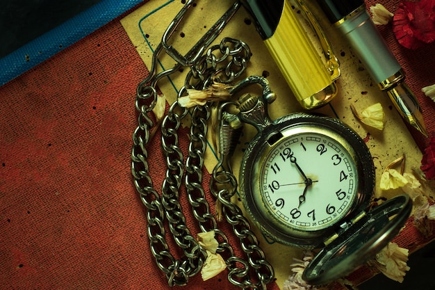 Vintage Taschenuhr und Messingstift auf altem Buch. Um 8 Uhr morgens. Draufsicht und Kopierraum. Bildung und Vintage-Stil-Konzept.