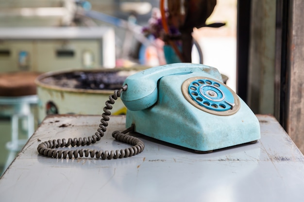 Vintage Telefon mit Drehknopf auf Metall Tisch