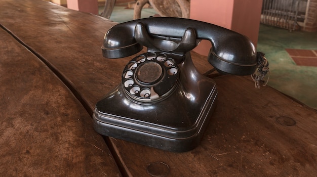 Foto vintage - telefone antigo preto retrô em uma mesa de madeira