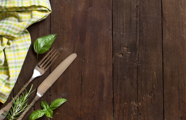 Vintage tenedor y cuchillo en una colorida servilleta sobre mesa de madera