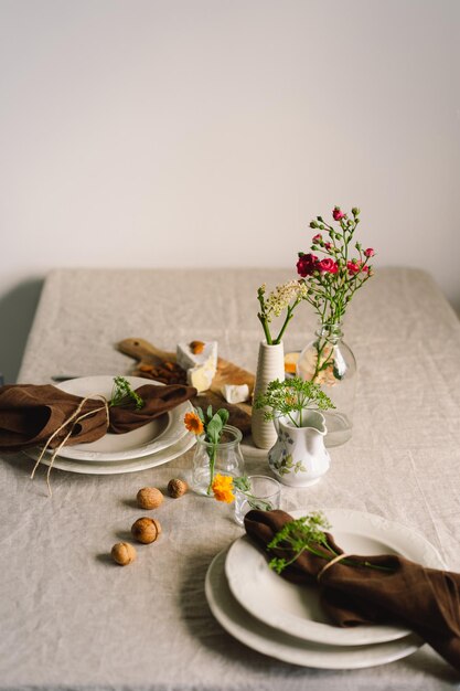 Vintage Tischdekoration mit Leinenservietten und Blumenschmuck Nahaufnahme Gemütliches, ruhiges Essen am Morgen in der Sonne