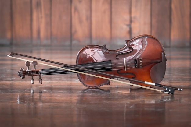 Vintage Violine mit Bogen auf Holz Hintergrund