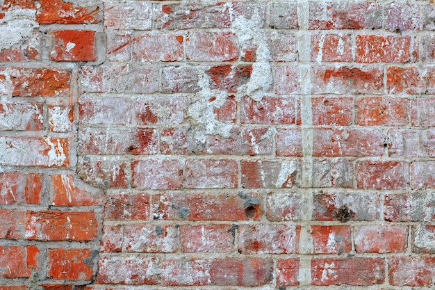 Vintage Wandstruktur aus rotem Backstein mit Zementmörtel und Farbflecken. Abstrakter Backsteinmauerhintergrund