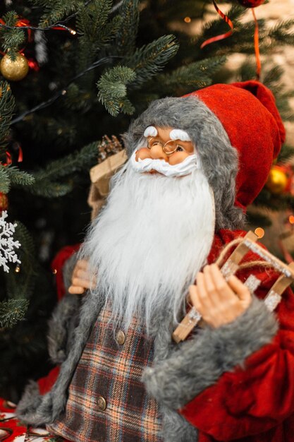 Vintager Weihnachtsmann mit einem Geschenkspielzeug, das den Weihnachtsbaum bereitsteht