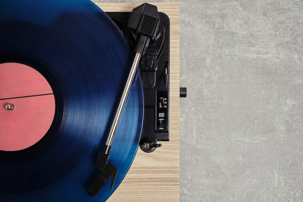 Vinyl-Plattenspieler mit blauer Platte installiert Top-View grauer Hintergrund