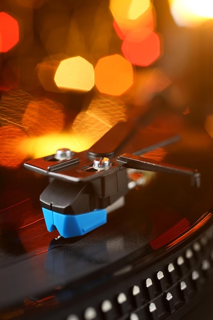 Vinyl-Player-Tonarm mit Schallplatte und verschwommenen Lichtern