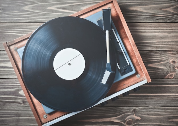 Vinylspieler mit Tellern auf einem Holztisch