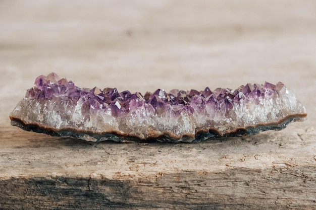 Violetter Amethystkristall auf hölzernem Hintergrund. Kopieren, leerer Platz für Text