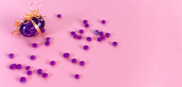 Violettes Osterei und Bonbons auf einem rosa Hintergrund