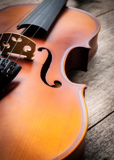 Violín marrón del primer en fondo de madera. Arte y música de fondo.