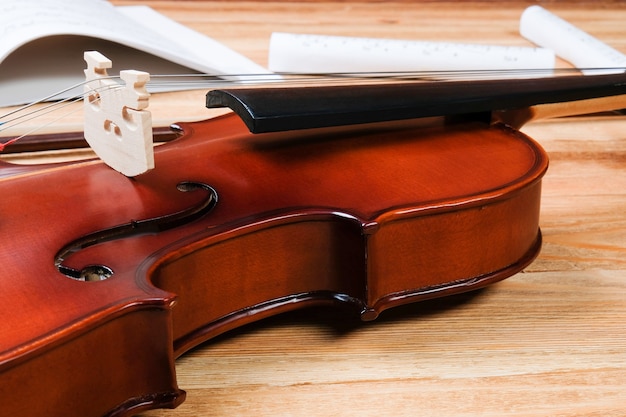 Violín y notas sobre una mesa de madera