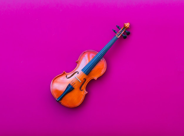 violín sobre fondo rojo aislado